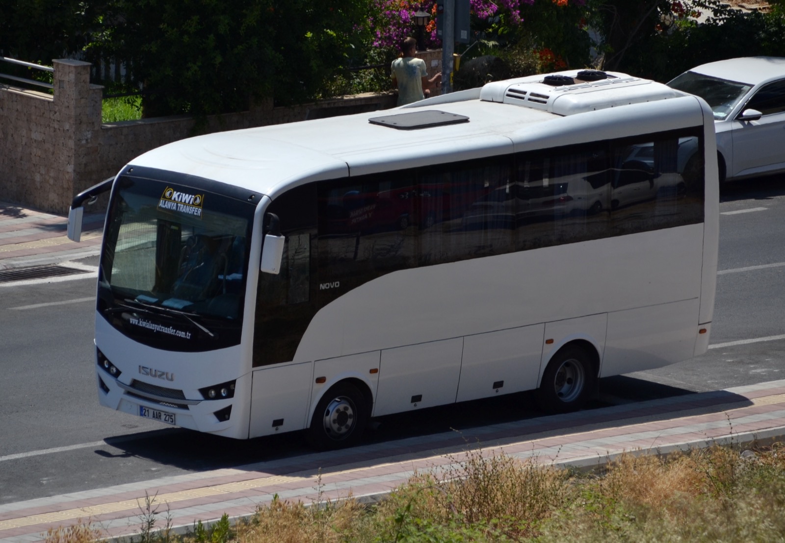 Alanya'da yolcu taşıyan beyaz bir Isuzu Novo midibüsü